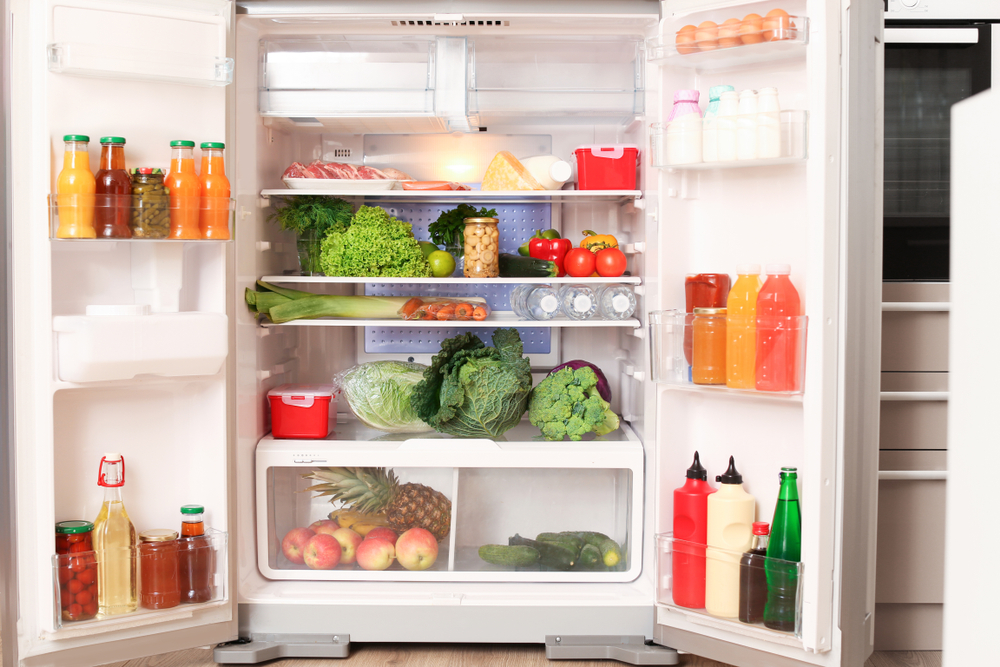 uma geladeira aberta com alimentos diversos dentro