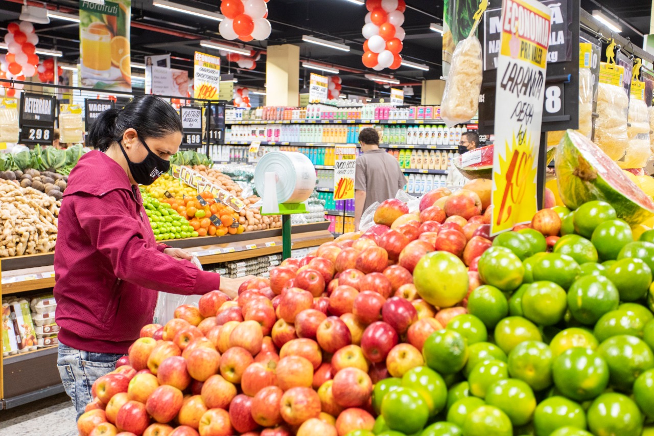 mulher de máscara fazendo compras no supermercado