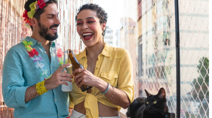 Carnaval em casa:  2022 mulher e namorado curtem na varanda ao lado do gato preto 
