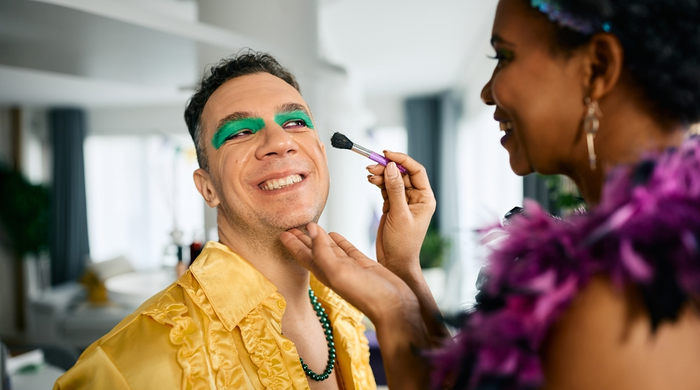 Carnaval em casa: mulher passando sombra verde em homem 